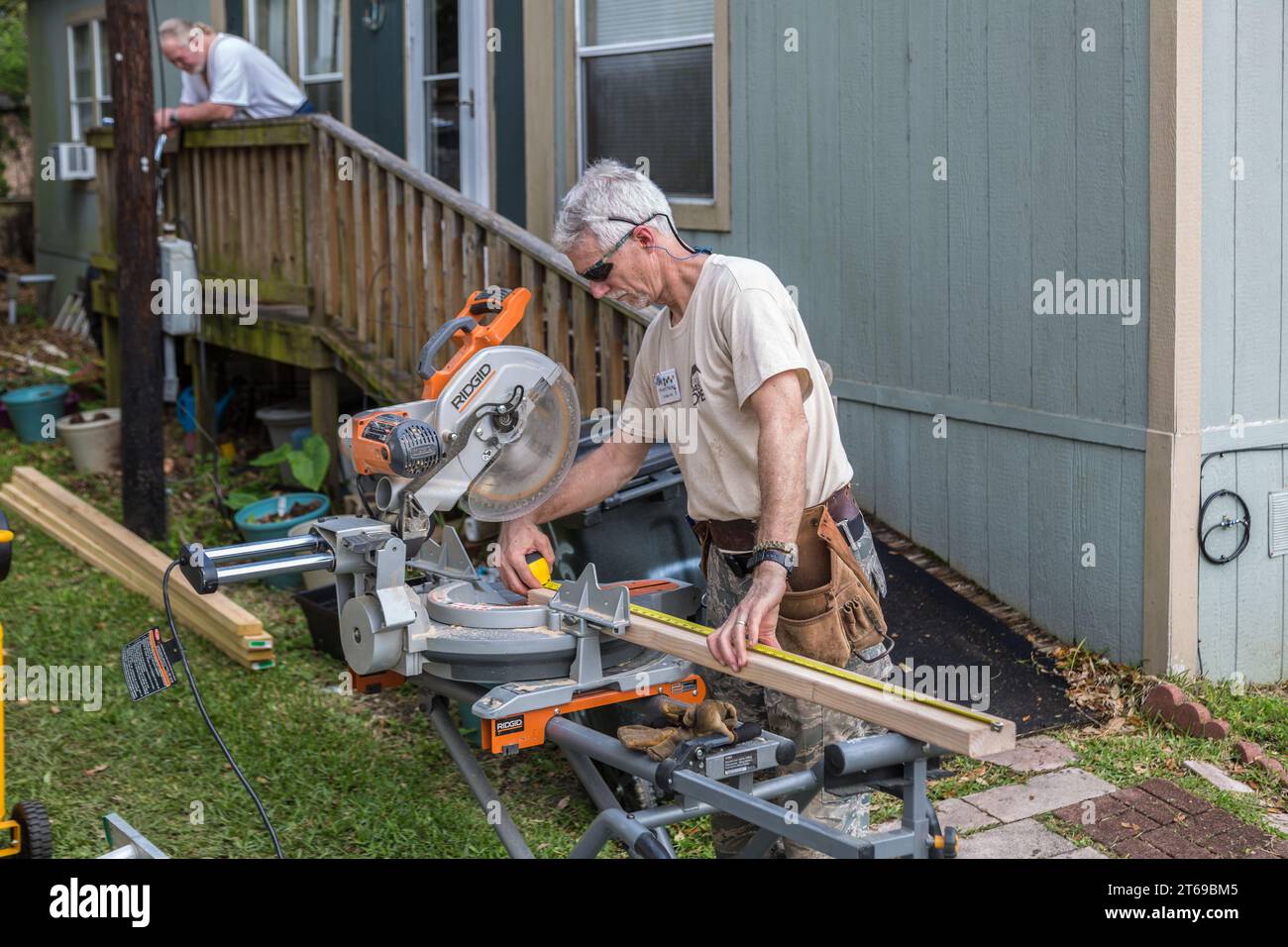 Member of 8 Days of Hope faith based charity volunteer team cutting lumber while repairing a home that was flooded in Houston, Texas Stock Photo