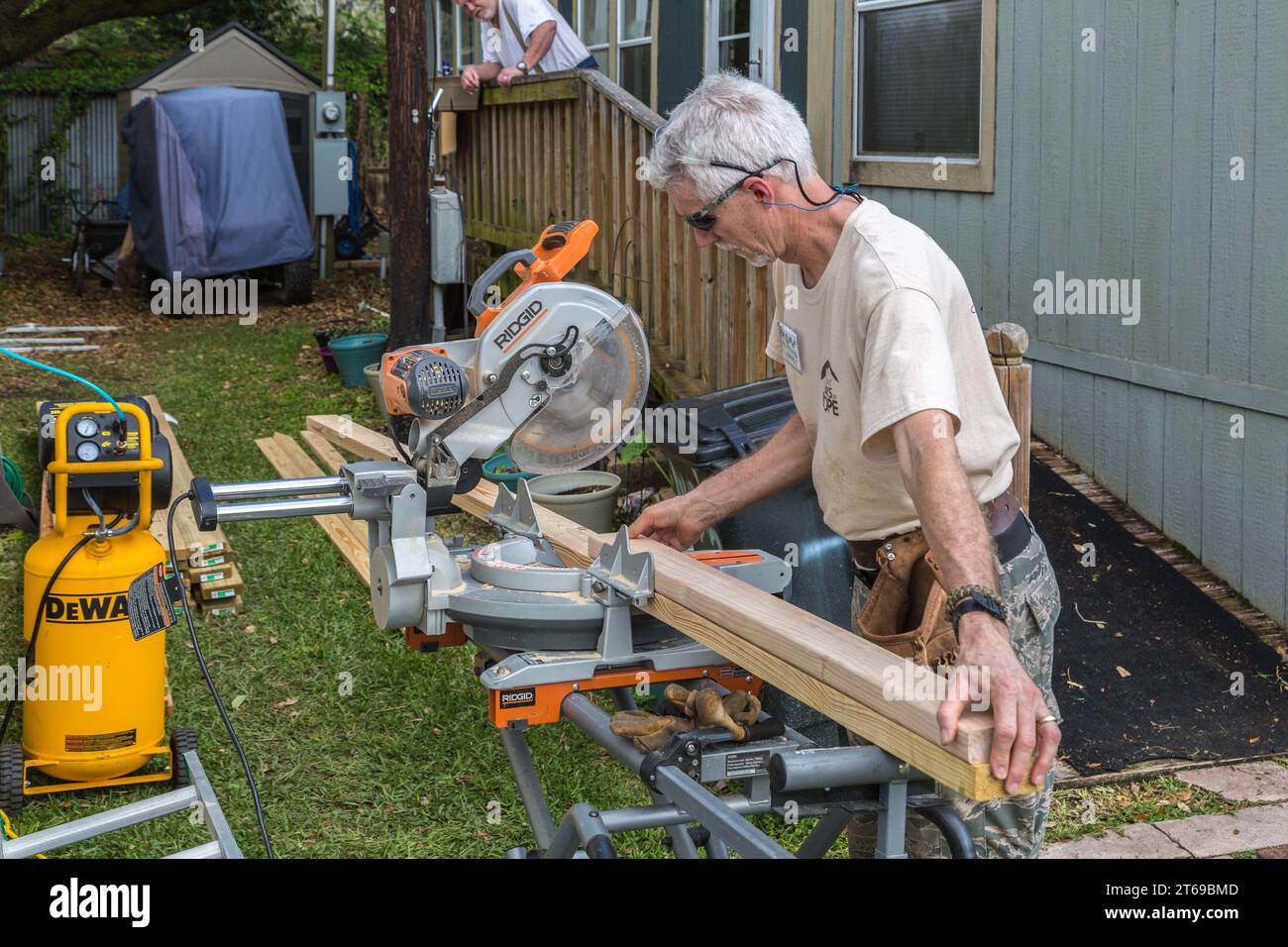 Member of 8 Days of Hope faith based charity volunteer team cutting lumber while repairing a home that was flooded in Houston, Texas Stock Photo