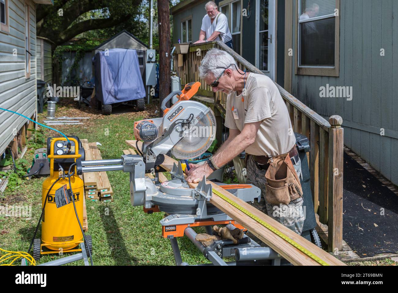 Member of 8 Days of Hope faith based charity volunteer team cutting lumber while repairing a home that was flooded in Houston, Texas Stock Photo