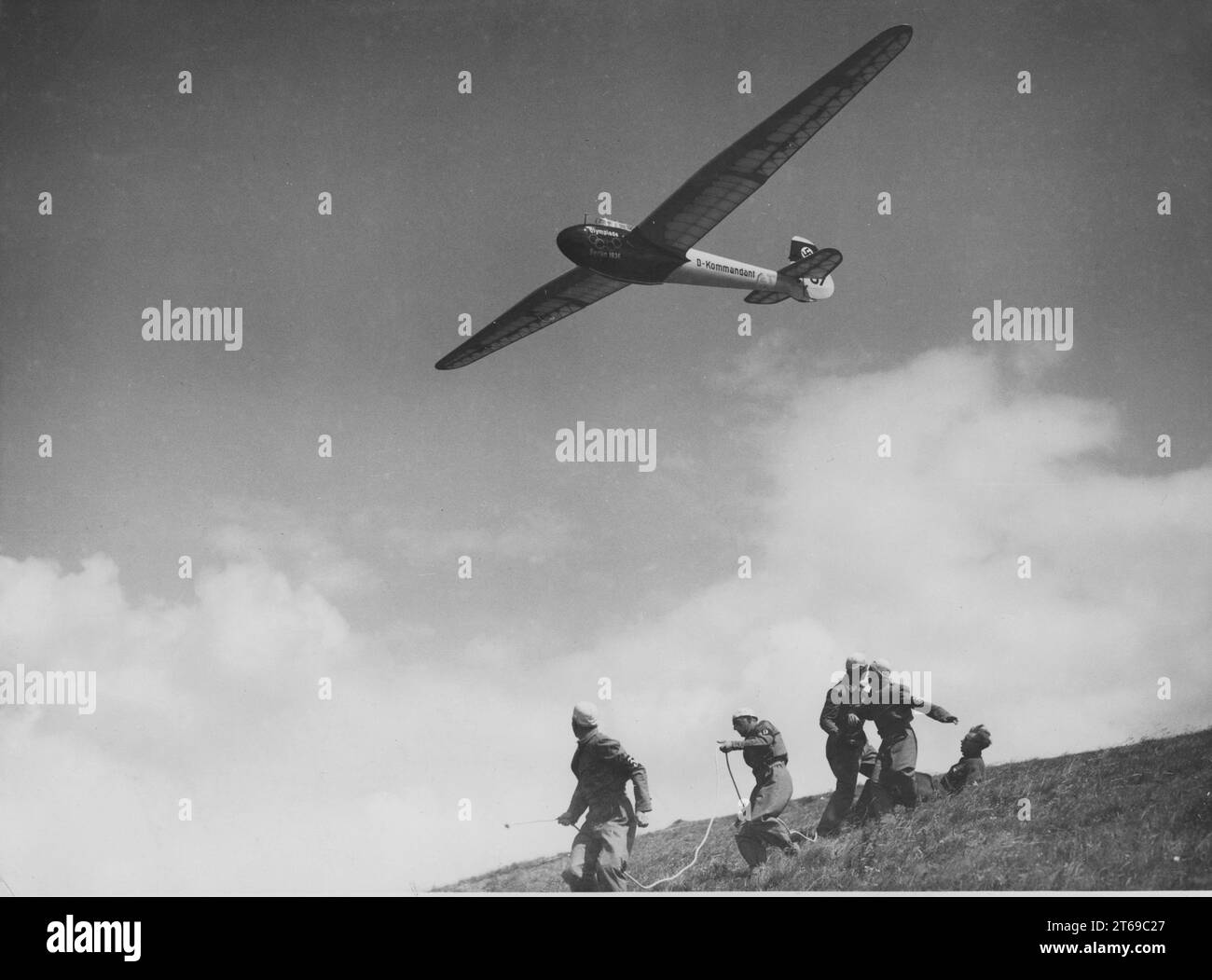 During a flying competition on the Rhön, a glider flies over members of the Hitler Youth. Presumably a glider Heron. It bears the inscription Olympic Games Berlin 1936 and D commander. [automated translation] Stock Photo