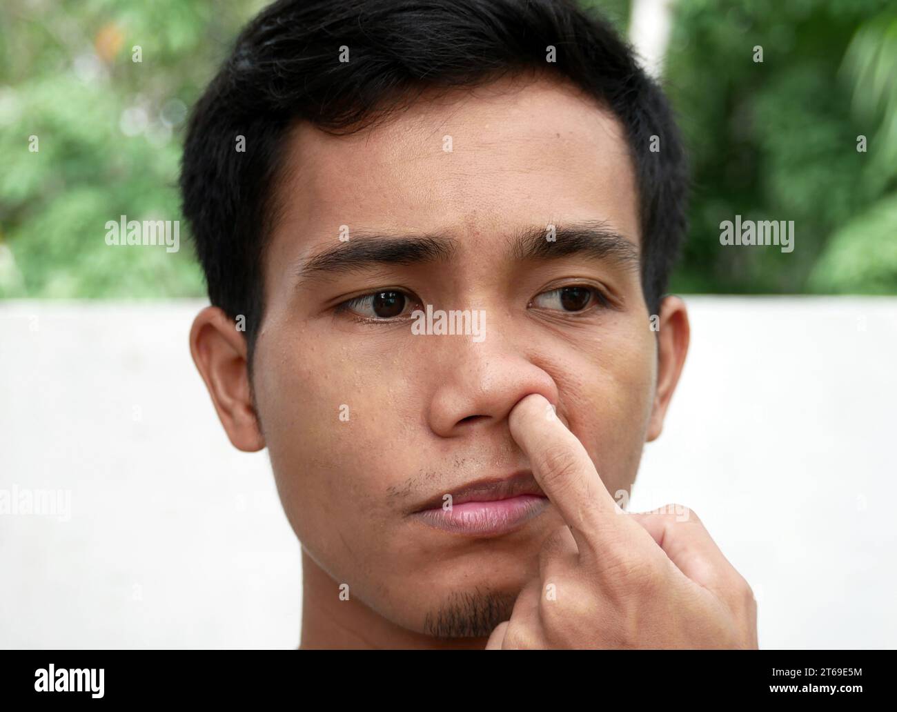 Asian male picking your nose on outdoor. Stock Photo