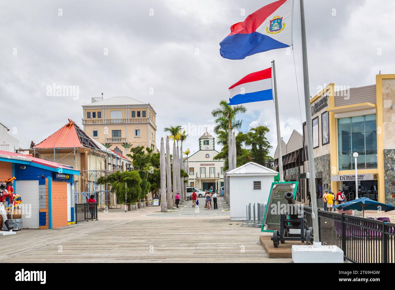 Tourists walking through tree lined Cyrus Wathey Square toward the courthouse in Philipsburg, Sint Maarten in the Caribbean Sea Stock Photo