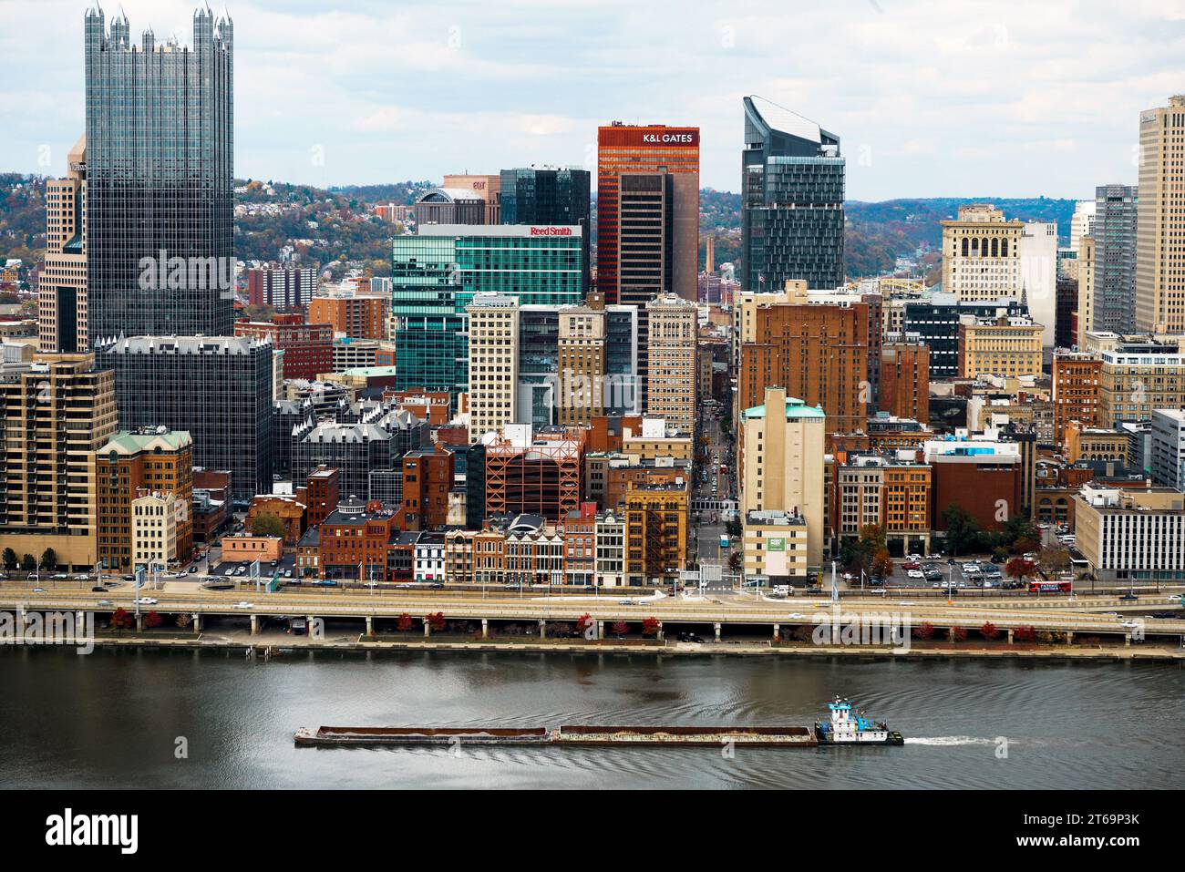 A barge moving along a river in front of the beautiful cityscape of Pittsburgh, Pennsylvania. Stock Photo