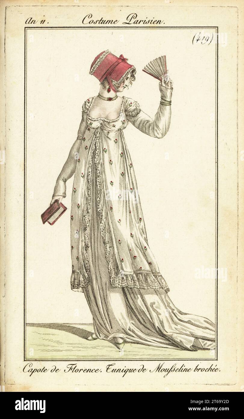 Fashionable woman with fan and almanac. She wears a Florentine hooded bonnet, brocaded muslin tunic dress, choker necklace. Capote de Florence. Tunique de Mousseline brochée. Handcoloured copperplate engraving from Pierre de la Mesangeres Journal des Dames et des Modes, Magazine of Women and Fashion, Paris, An 11, 1802. Illustrations by Carle Vernet, Jean-Francois Bosio, Dominique Bosio and Philibert Louis Debucourt, engraved by Pierre-Charles Baquoy. Stock Photo