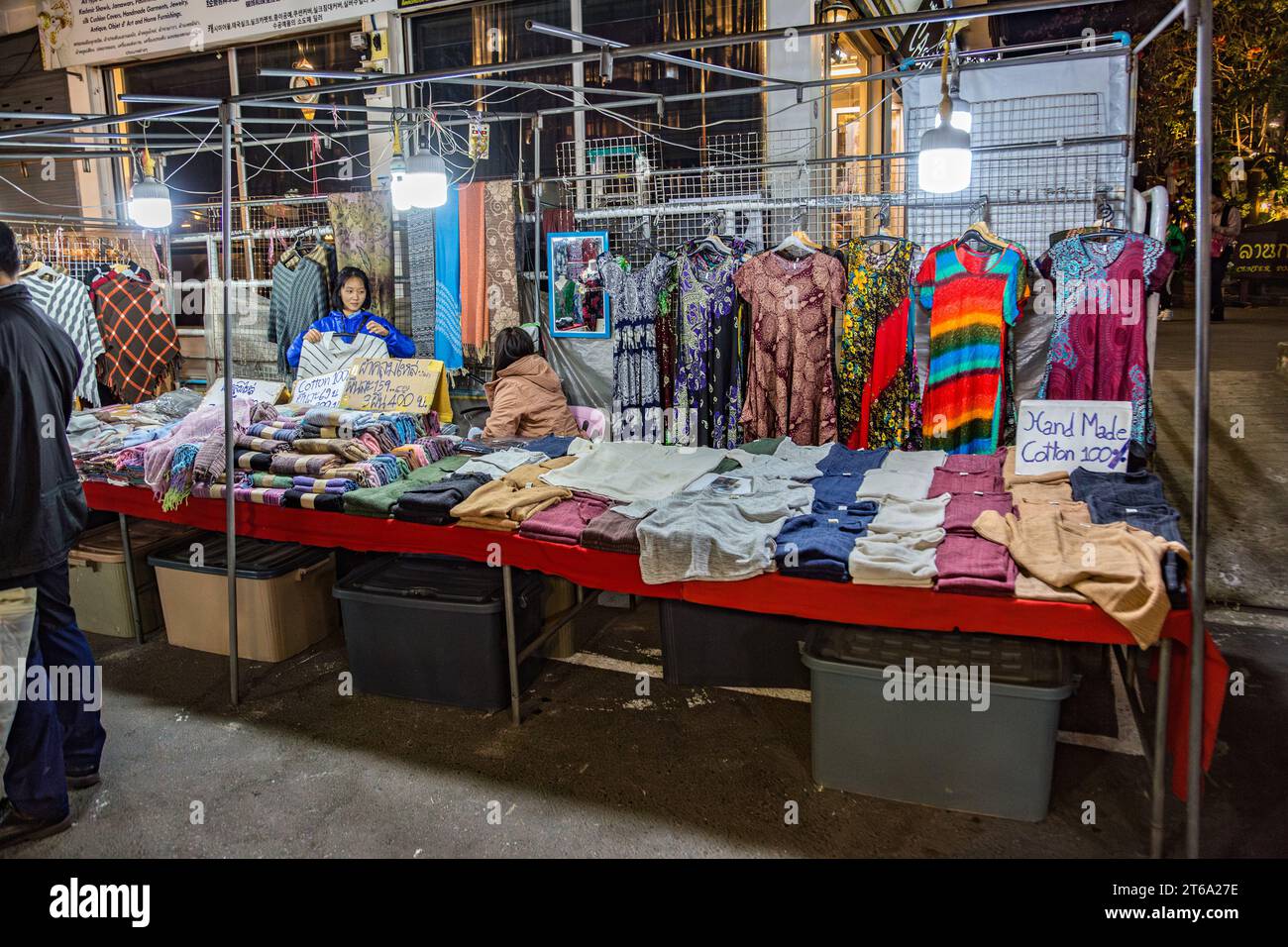 Thai women selling hand made cotton garments at the Night Market in downtown Chiang Rai, Thailand Stock Photo