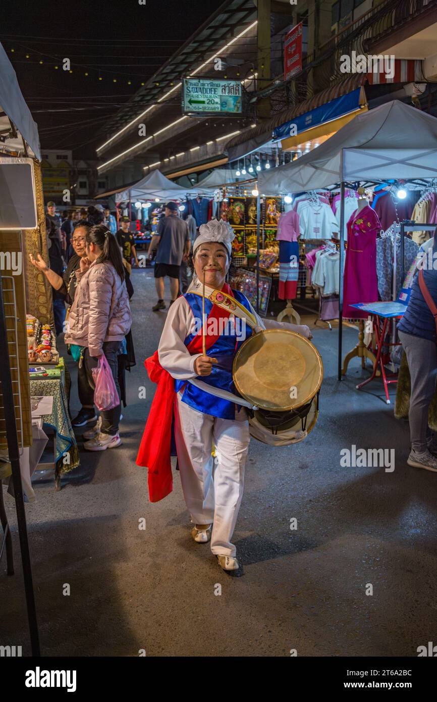 Smiling Thai woman beating a drum as she dances through the Night ...