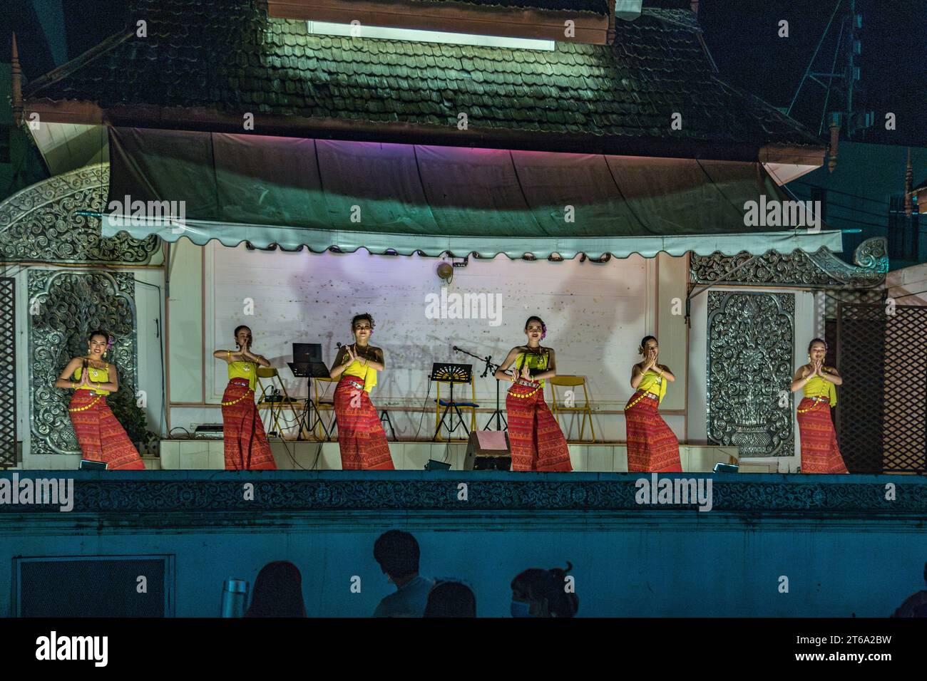 Traditional Thai dancers perform on a lighted stage at the night market ...