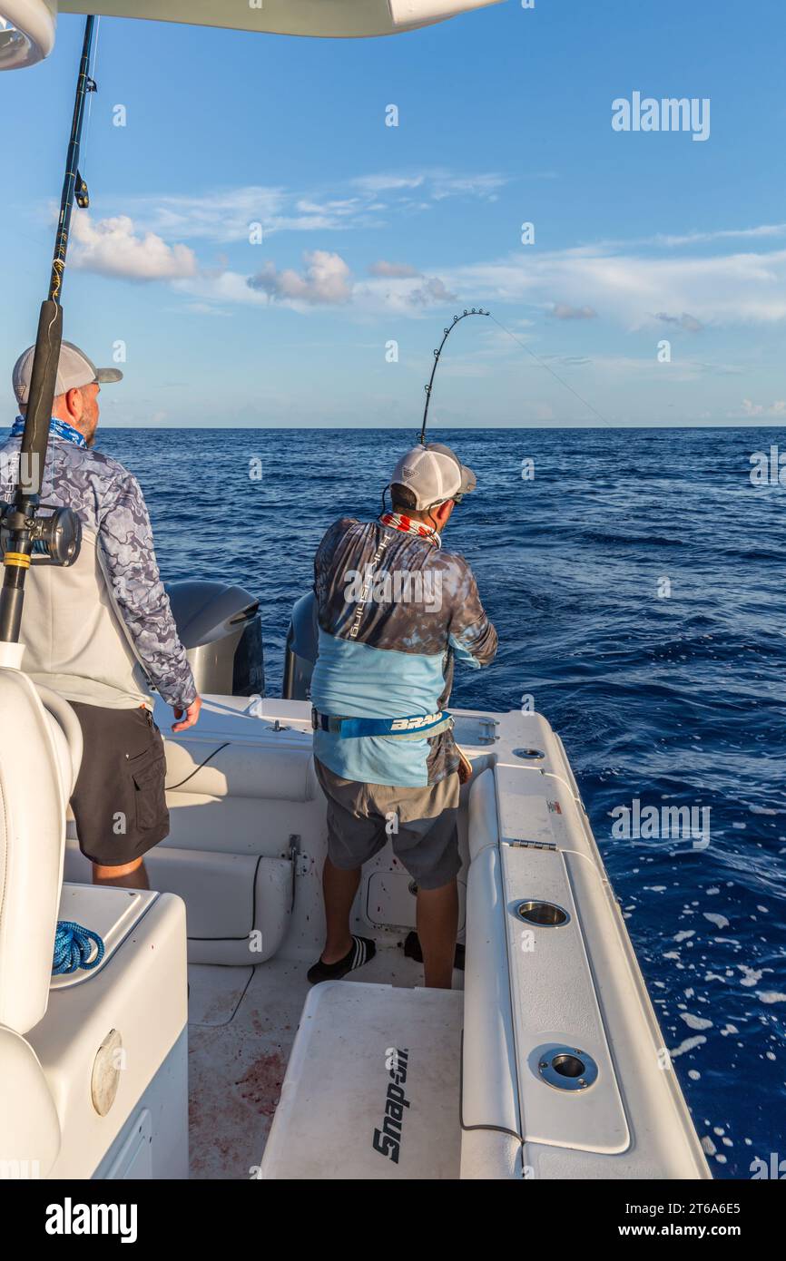 Offshore fisherman reeling in a fish in the Gulf of Mexico Stock Photo