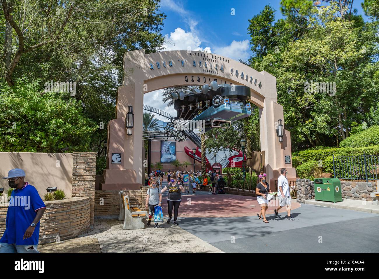 Masked park guests exiting under the entrance sign for the Rock 'n' Roller Coaster ride at Disney's Hollywood Studios theme park Stock Photo