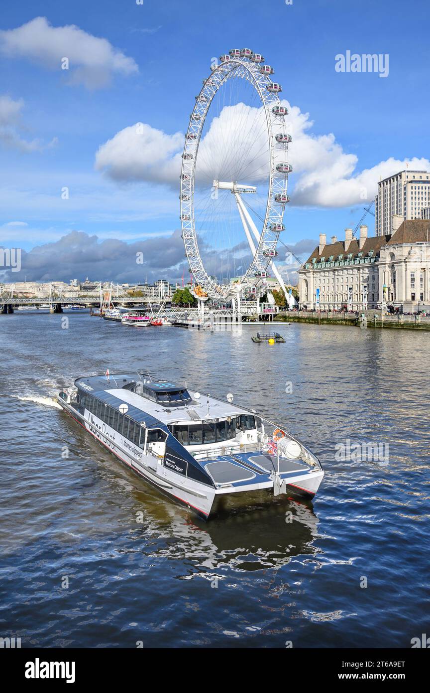 London, UK. Mercury Clipper - Uber Boat, by Thames Clippers, passing the London Eye / Millennium Wheel and Country Hall, on the River Thames, seen fro Stock Photo