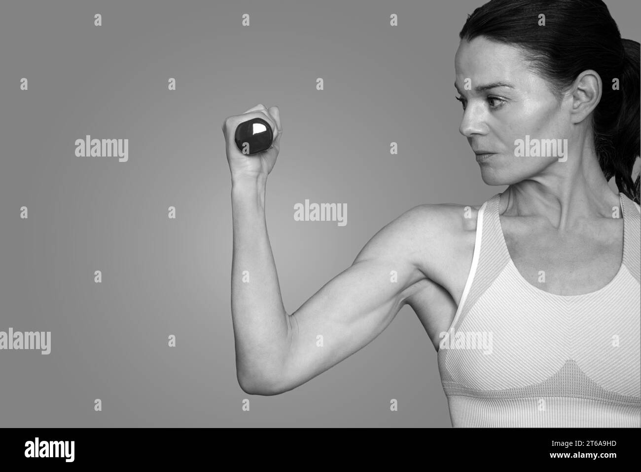 fit woman using a hand weight dumbell, close up, black and white. Stock Photo