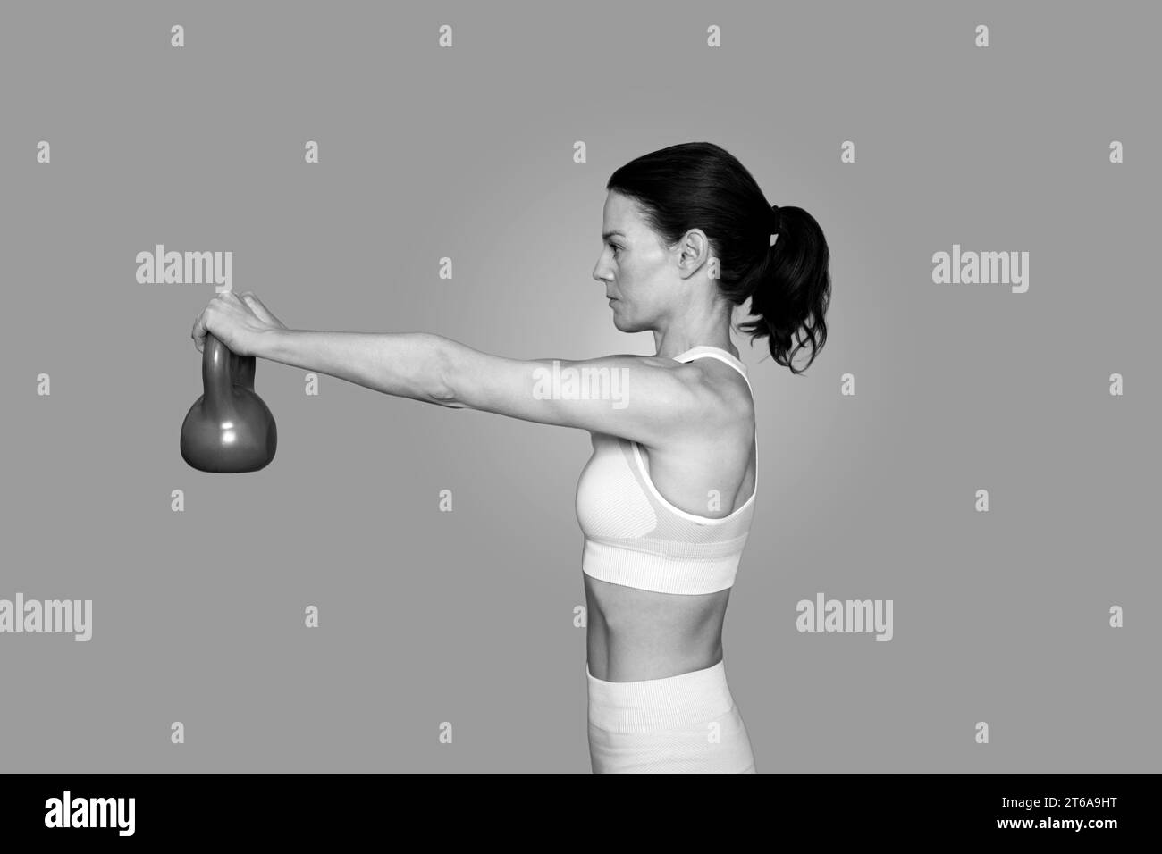fit woman using a kettle bell weight, close up, black and white. Stock Photo