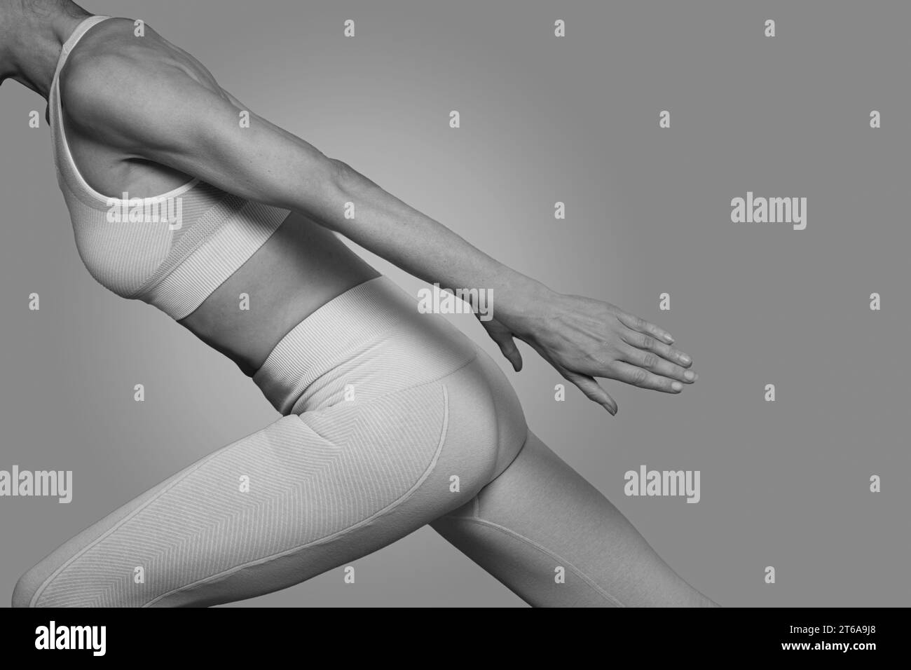 Fit woman doing stetching exercises, close up black and white. Stock Photo