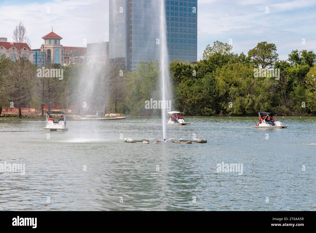 Young families piloting pedal boats around the fountain on Lake