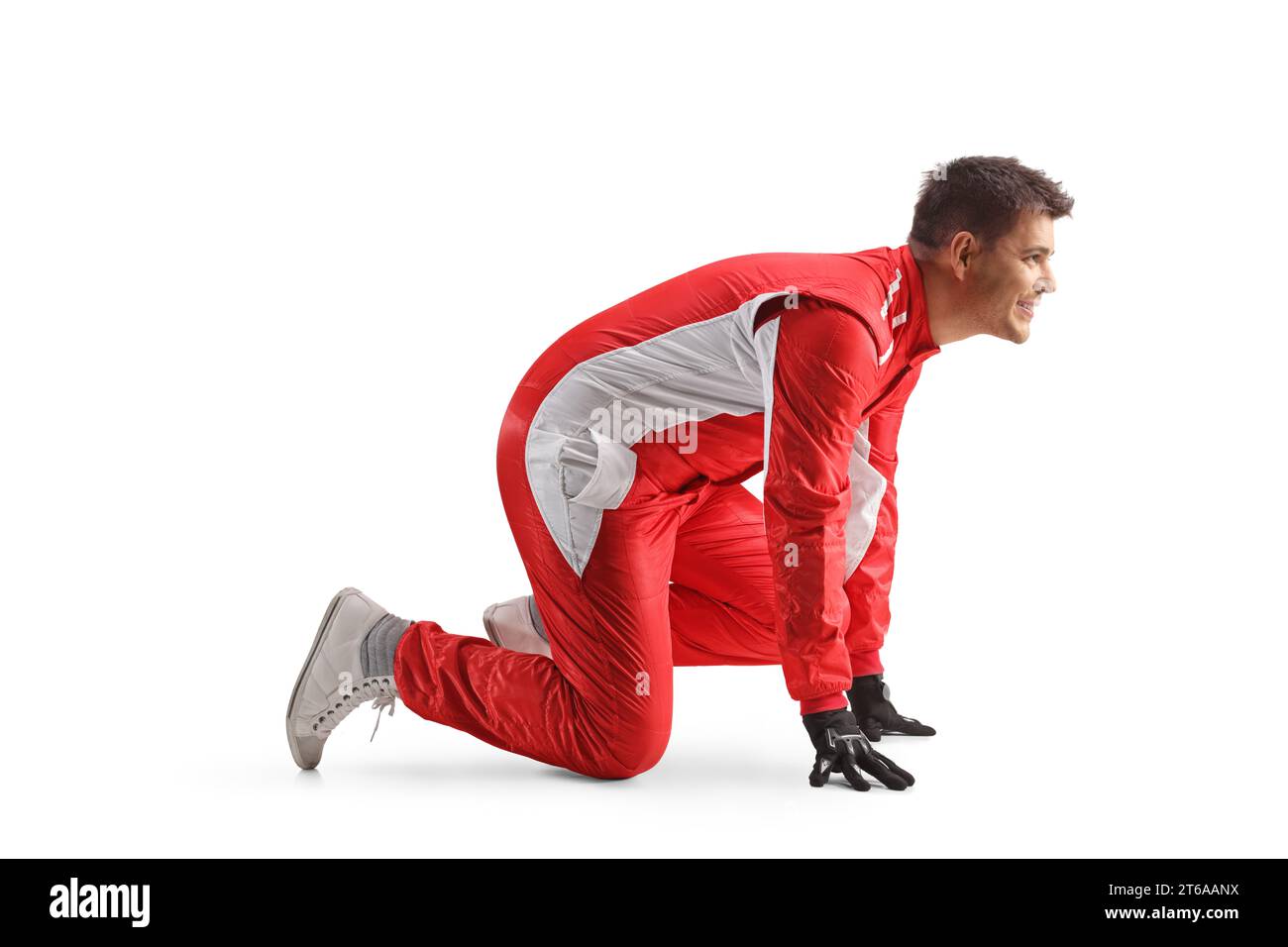 Full length profile shot of a car racer in a red suit starting a running race isolated on white background Stock Photo
