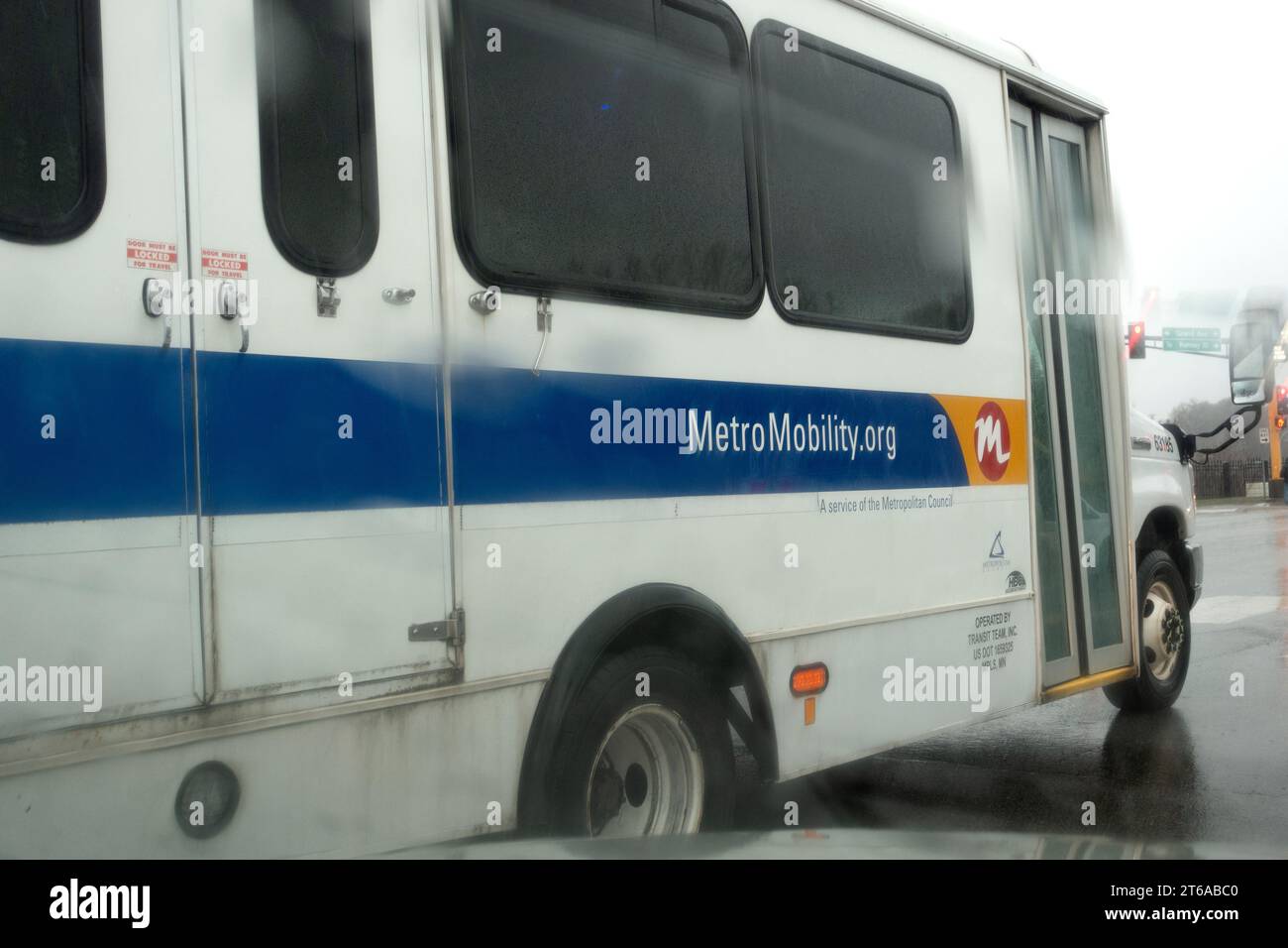 Large Metro Mobility transport van traveling in the rain for transport of the handicapped and older individual .  St Paul Minnesota MN USA Stock Photo