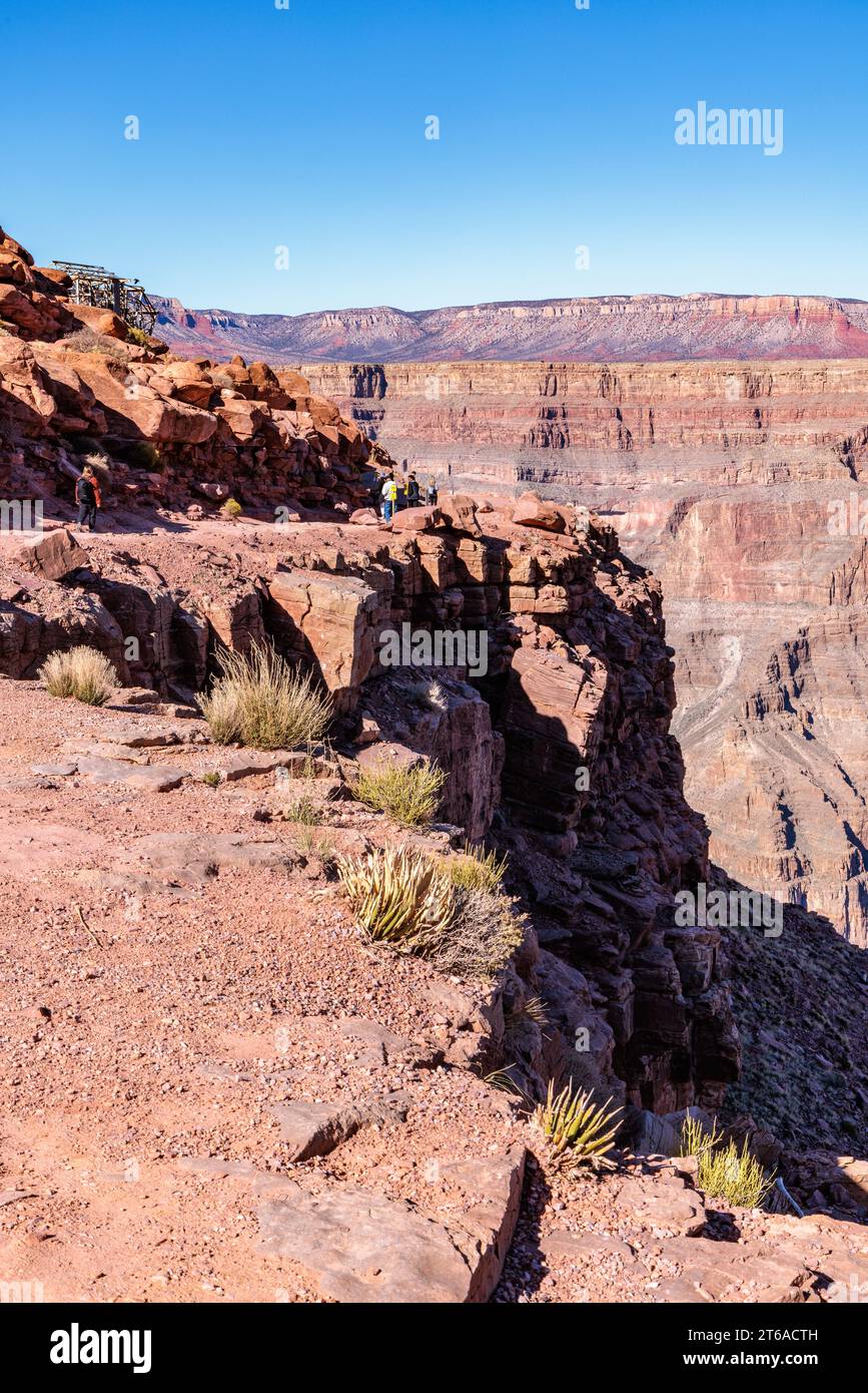 Visitors walk along the canyon rim to the location of the old mining cable structure at Guano Point in Grand Canyon West near Peach Springs, Arizona Stock Photo