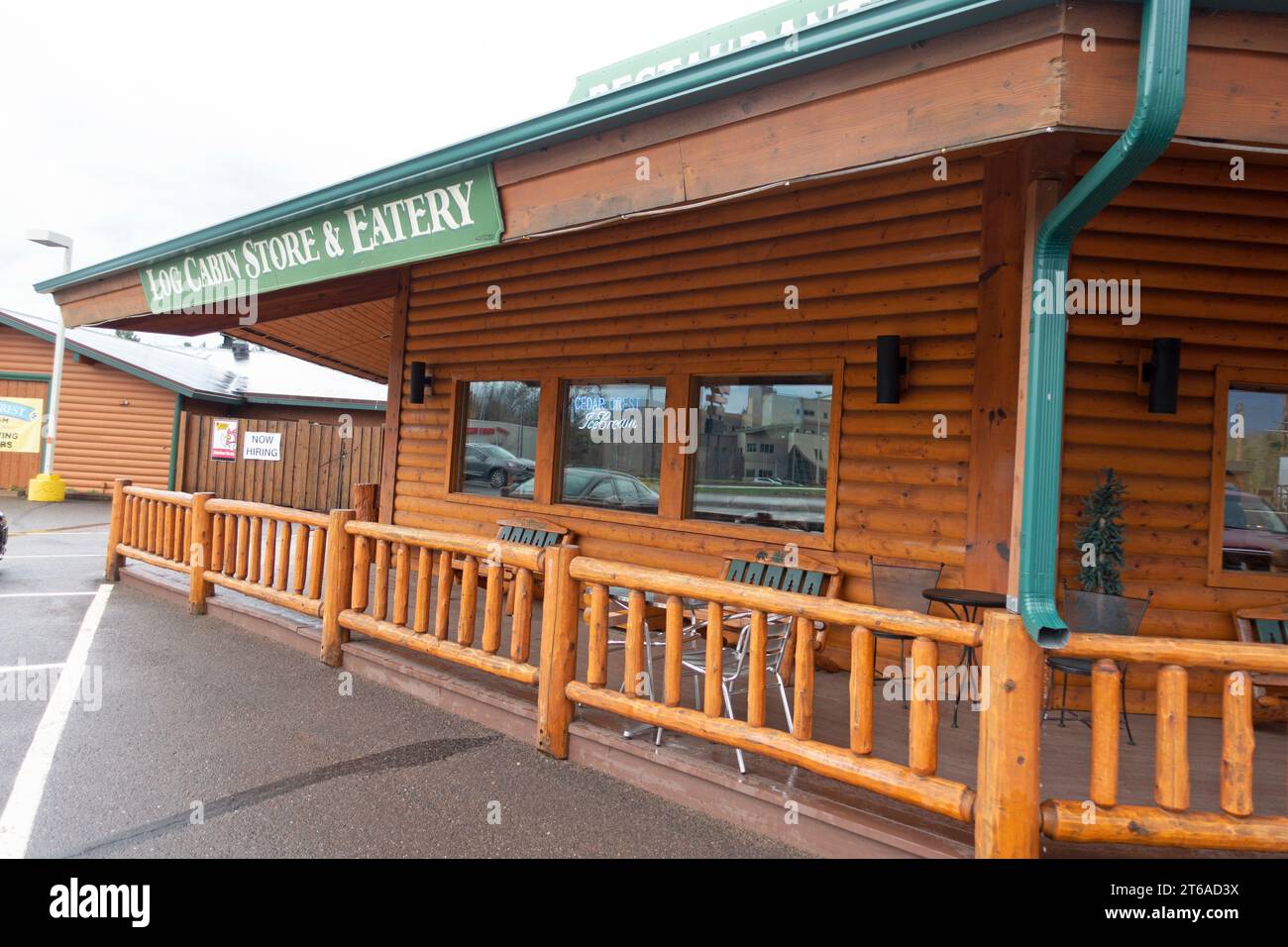 Log Cabin Store & Eatery restaurant with a log cabin motif and long deck with wooden railing. Danbury Wisconsin WI USA Stock Photo