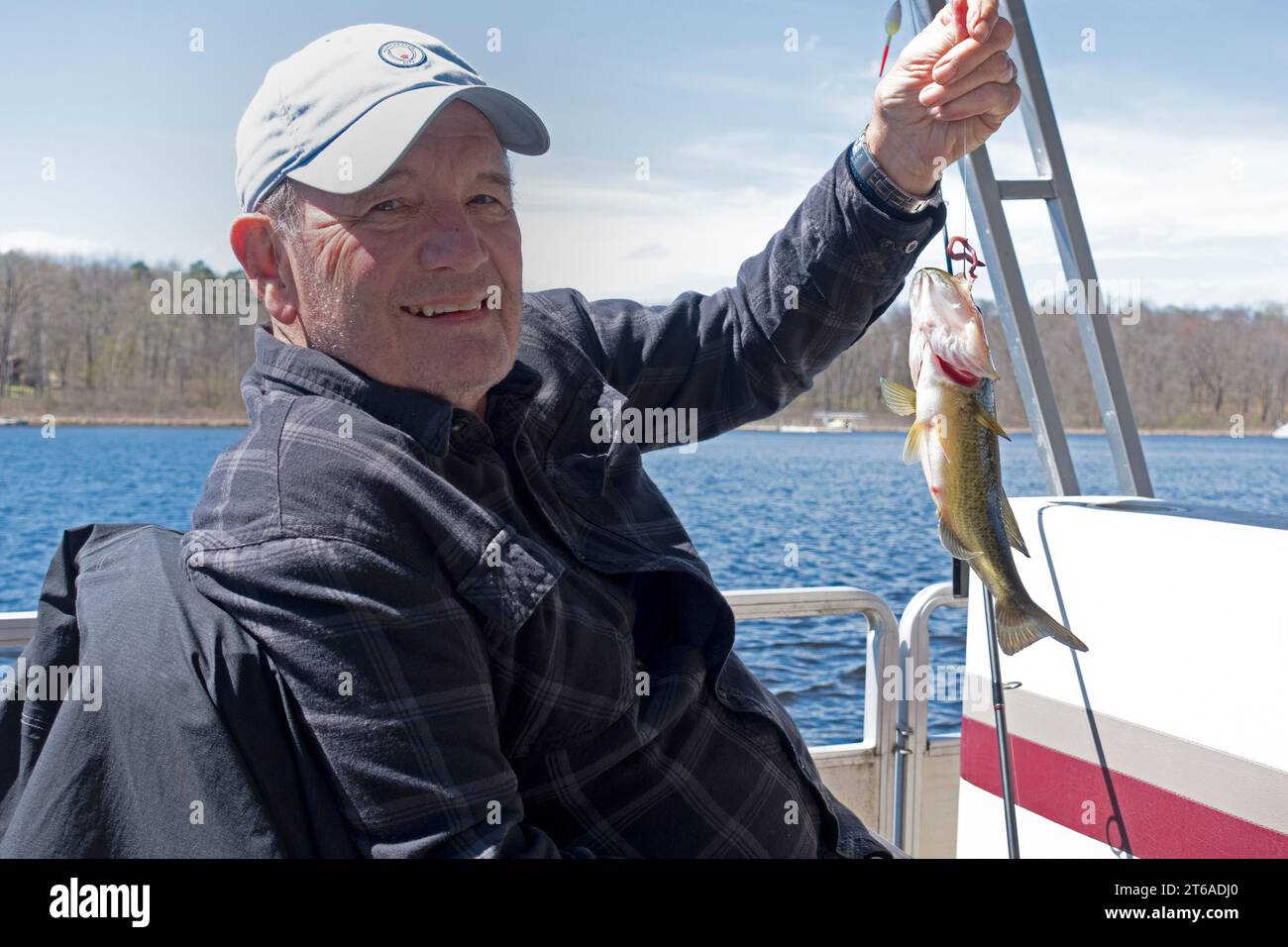 Proud angler displaying a possible large mouth bass on Gull Lake fishing opener and returned to the water to grow up.  Nisswa Minnesota MN USA Stock Photo