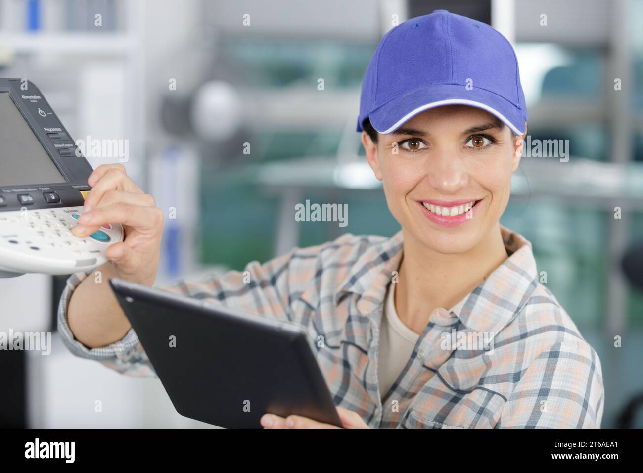 happy woman smiling at the camera fixing a printer Stock Photo
