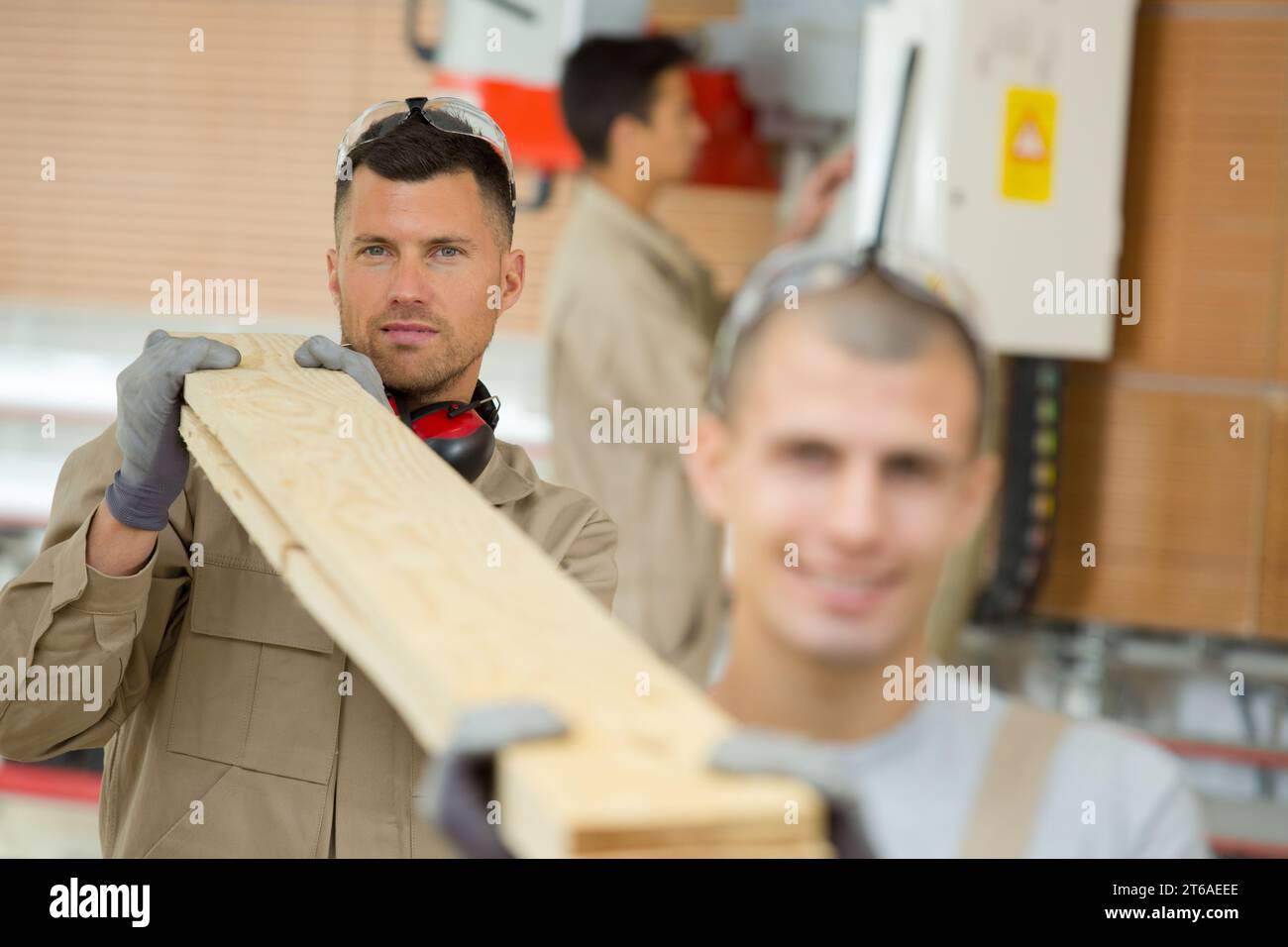 construction workers carrying boards at construction site Stock Photo