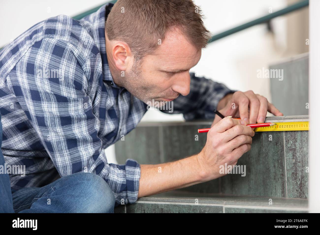 young worker using tape measure for measuring staircases Stock Photo