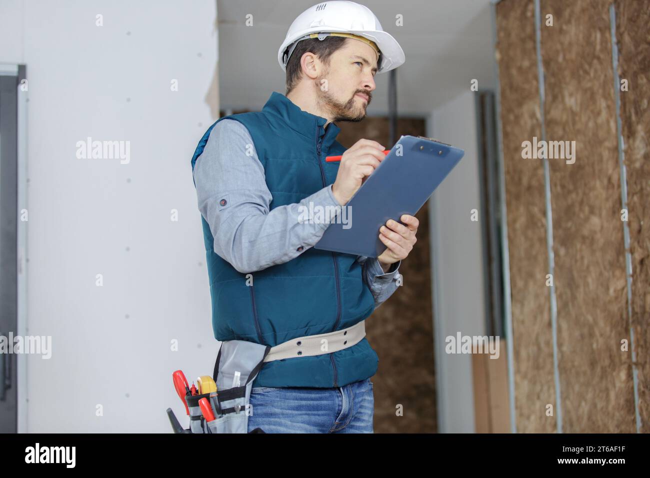 male builder writting on clipboard Stock Photo