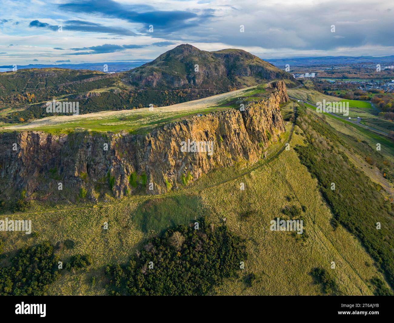 Aerial view of Salisbury Crags with Arthur’s Seat to rear  in Holyrood Park, Edinburgh, Scotland, UK Stock Photo
