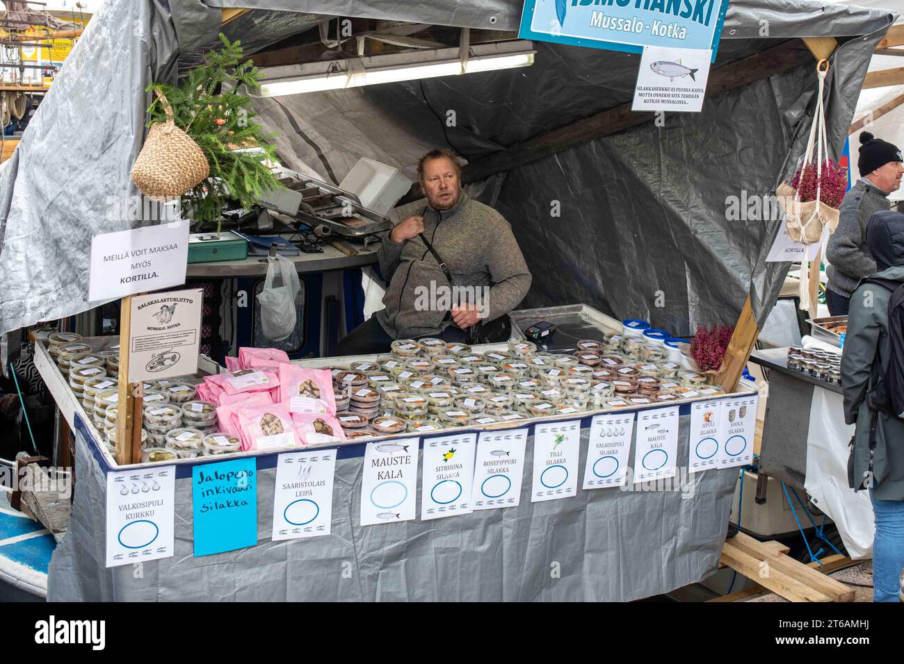 Vendor on boat selling Baltic herring products at Stadin silakkamarkkinat or Baltic Herring Fair in Helsinki, Finland Stock Photo