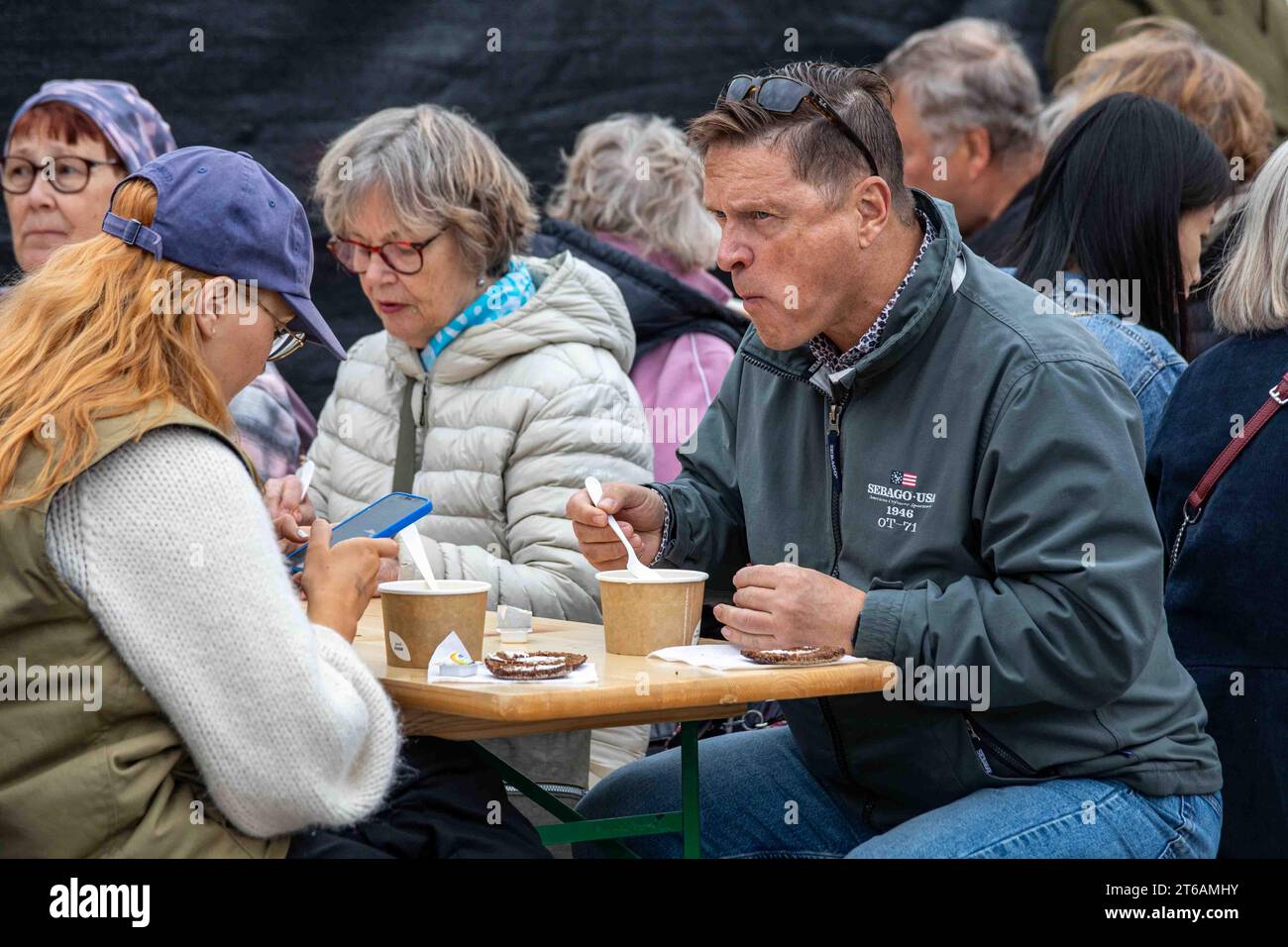 People eating fish soup at Baltic Herring Fair or Stadin silakkamarkkinat on Market Square in Helsinki, Finland Stock Photo