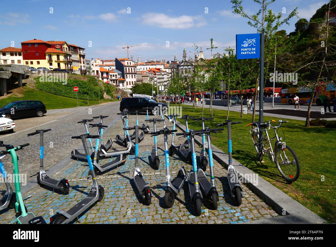Electric scooters parked at sharing point, Igreja dos Congregados church and city hall tower in distance, Ribeira, Porto / Oporto, Portugal Stock Photo