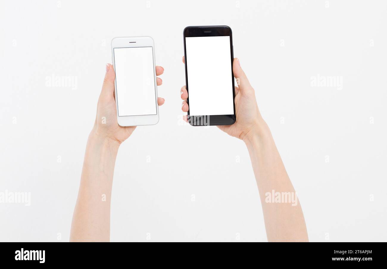 Hand holding white and black phones isolated on white clipping path inside. Top view.Mock up.Copy space.Template.Blank. Stock Photo