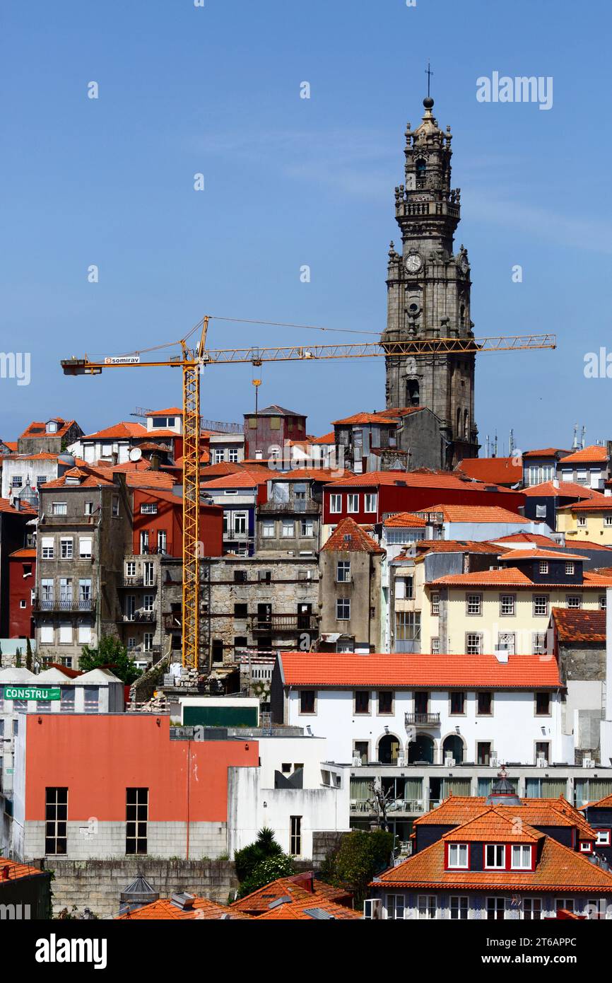 Yellow tower crane, old houses in Ribeira district and Torre dos Clérigos church tower, Porto / Oporto, Portugal Stock Photo