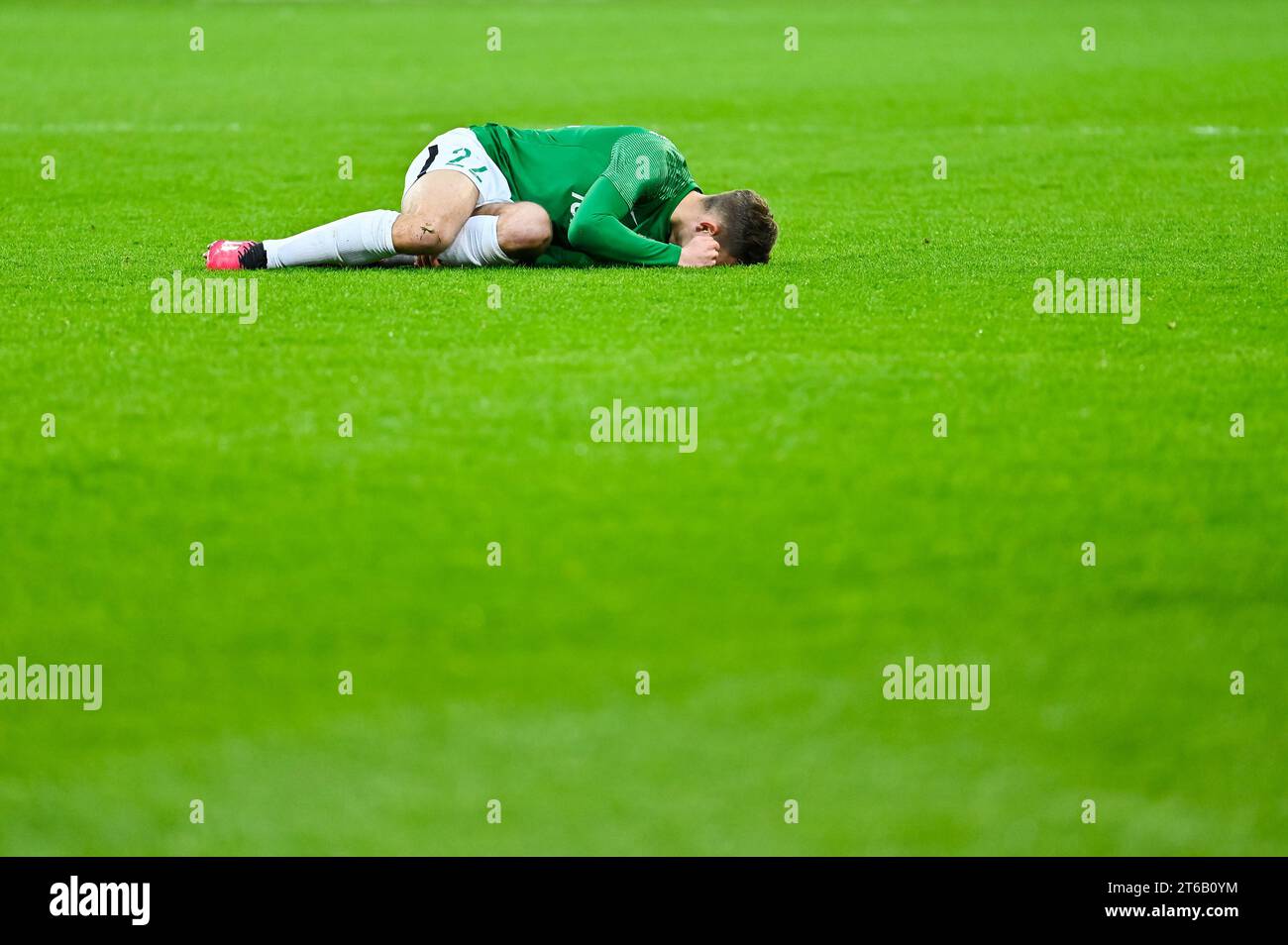 The injured footballer lies on the pitch Stock Photo - Alamy