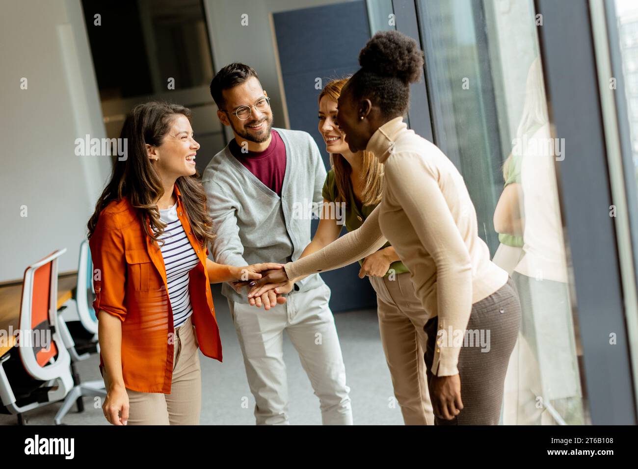 Young multiethnic startup team hold hands togetherat the modern office Stock Photo