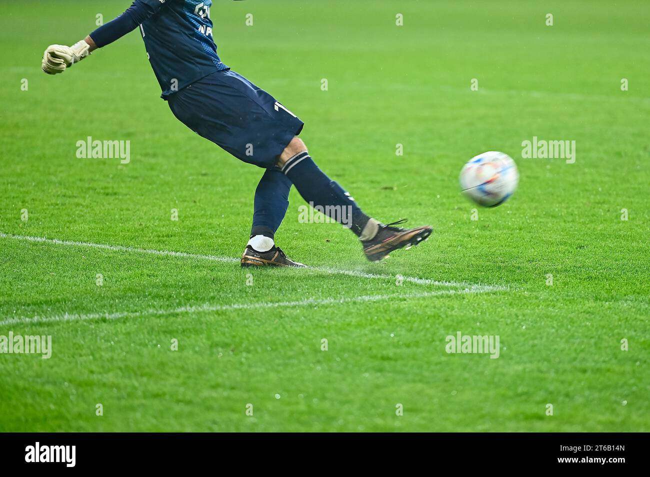 Football goalkeeper kicks ball. Player's legs and the ball during ...