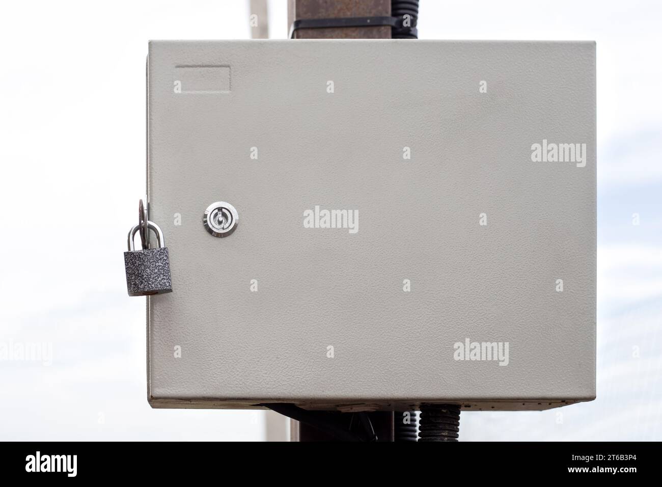 An electrical panel in an iron box, locked and hanging on a pole. Input of electricity into the house. Stock Photo