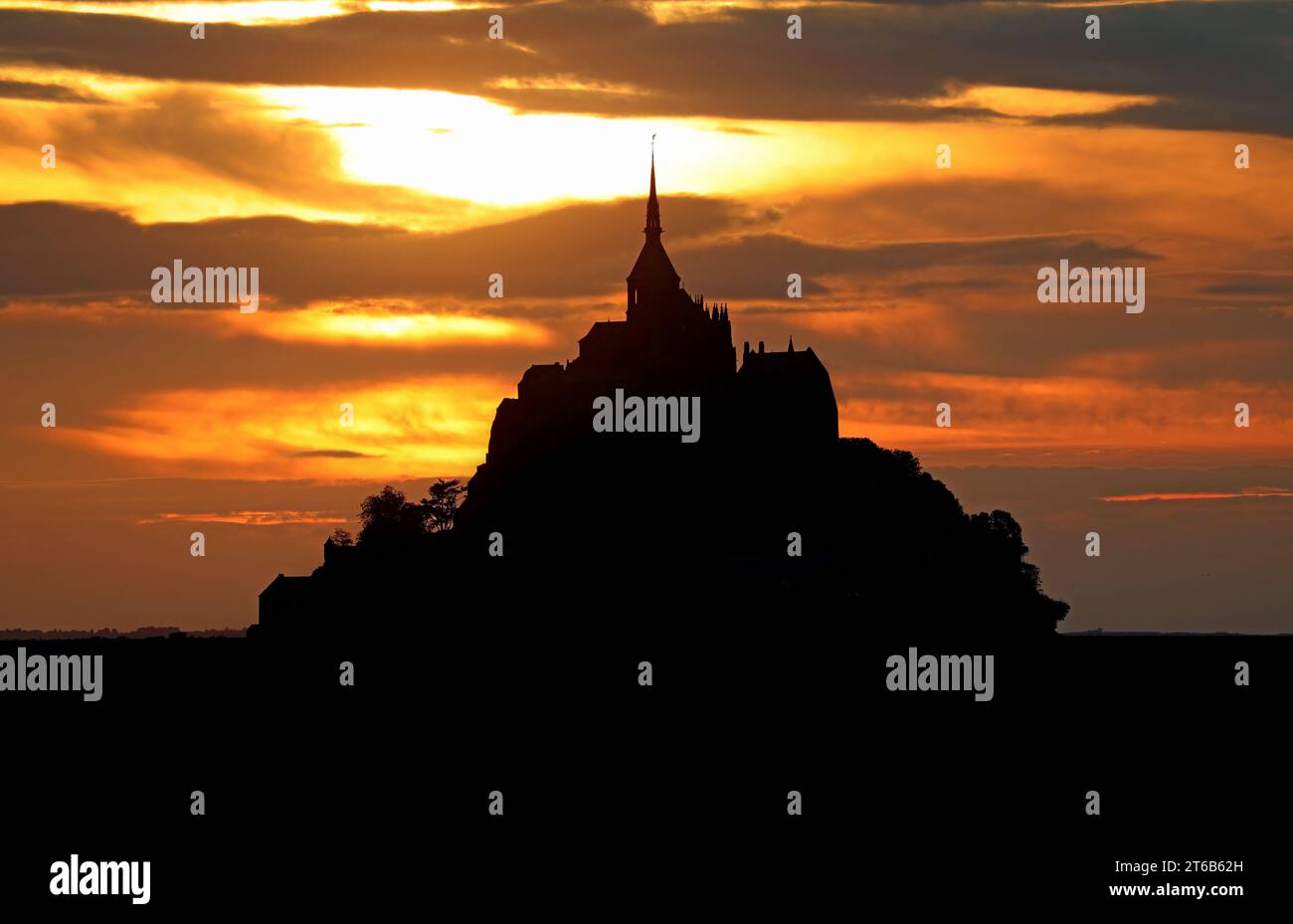 Mont-Saint-Michel, FRA, France - August 22, 2022: abbey located on the tidal island in Normandy at sunset Stock Photo