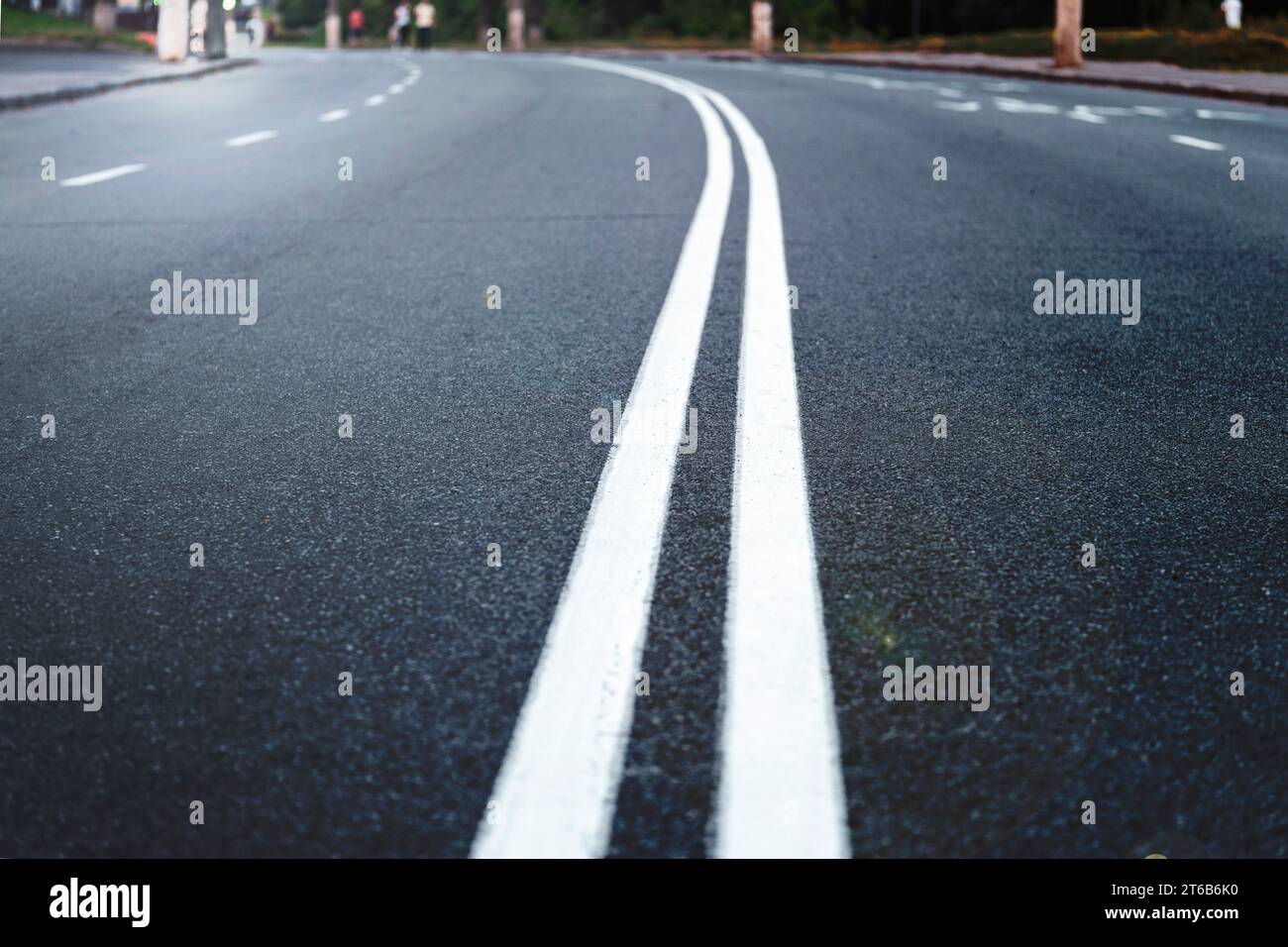 The asphalted road with two continuous white strips. The highway with a