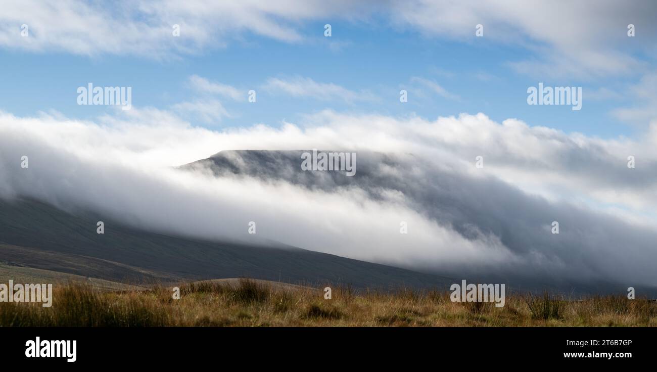 Ingleborough fell, one of the Three Peaks in the Yorkshire Dales National Park, UK, with a cloud inversion flowing over it. Stock Photo