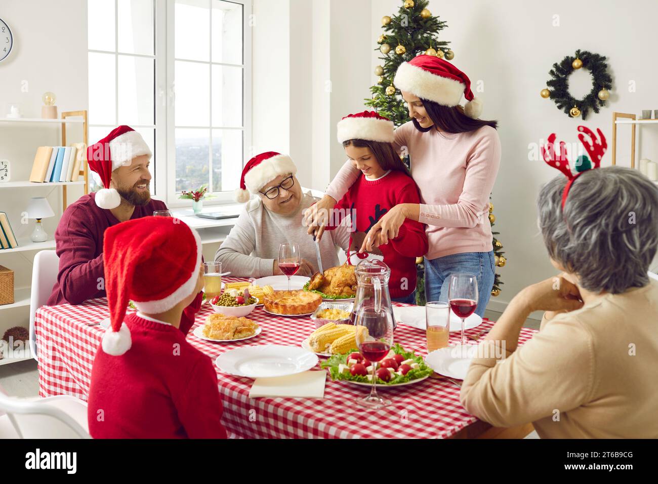 Big family has a Christmas Thanksgiving dinner with turkey sitting at table in living room at home. Stock Photo