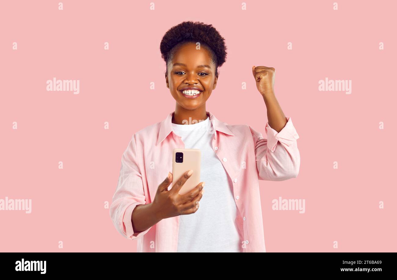 Overjoyed African American woman makes YES gesture with hand when sees ...