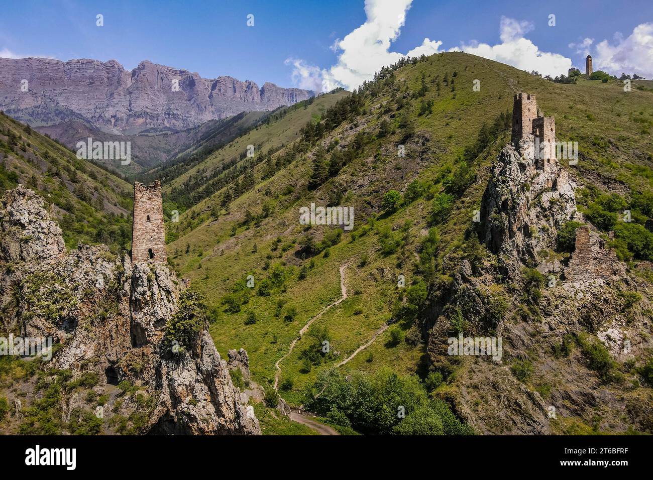 The aerial photo of ancient Ingush towers Vovnushki on the rock cliffs in the scenic mountains of Ingushetia Republic, Caucasus, southern Russia. Stock Photo