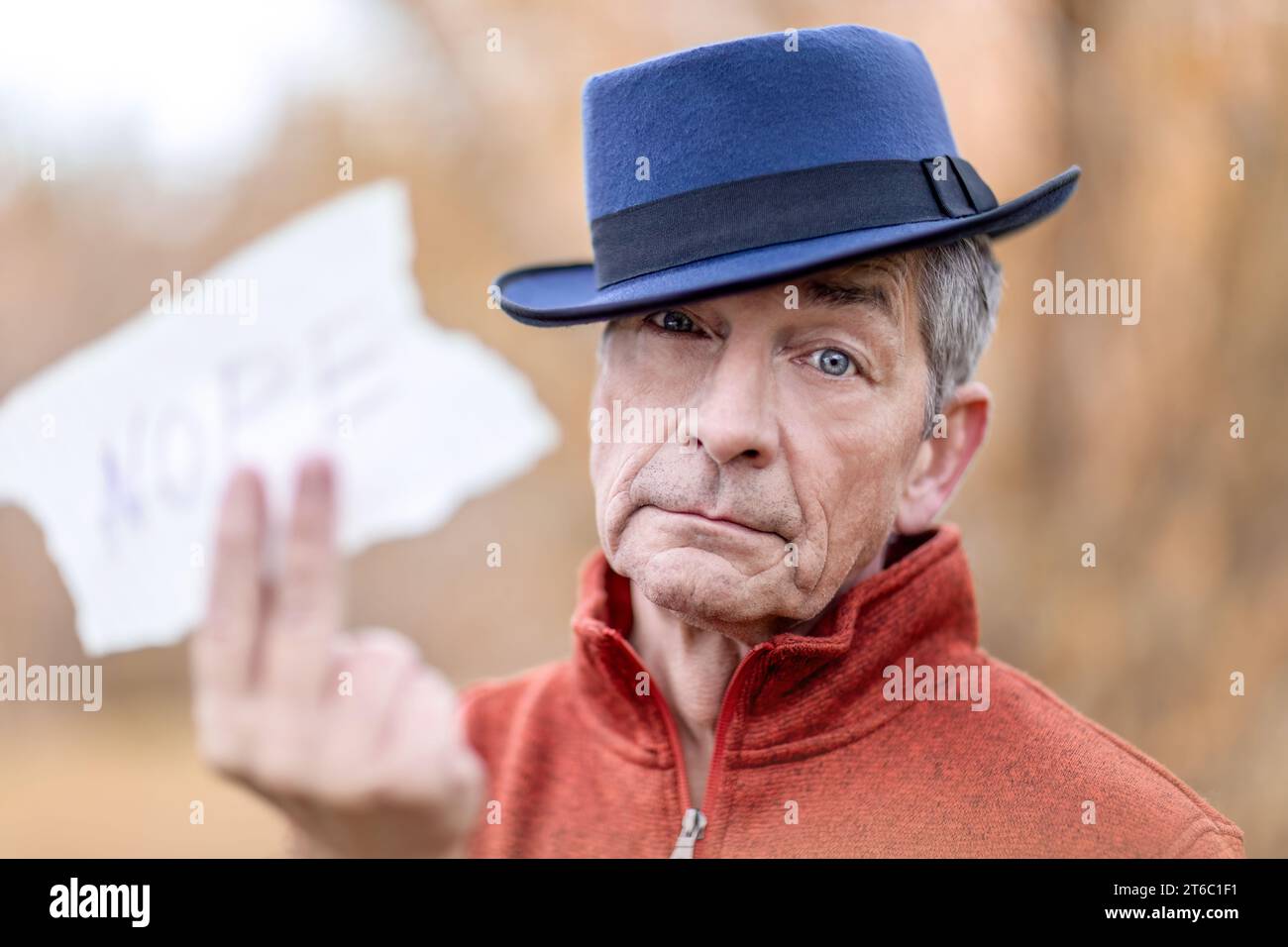 Head portrait of an elderly man holding a sign, text space Stock Photo