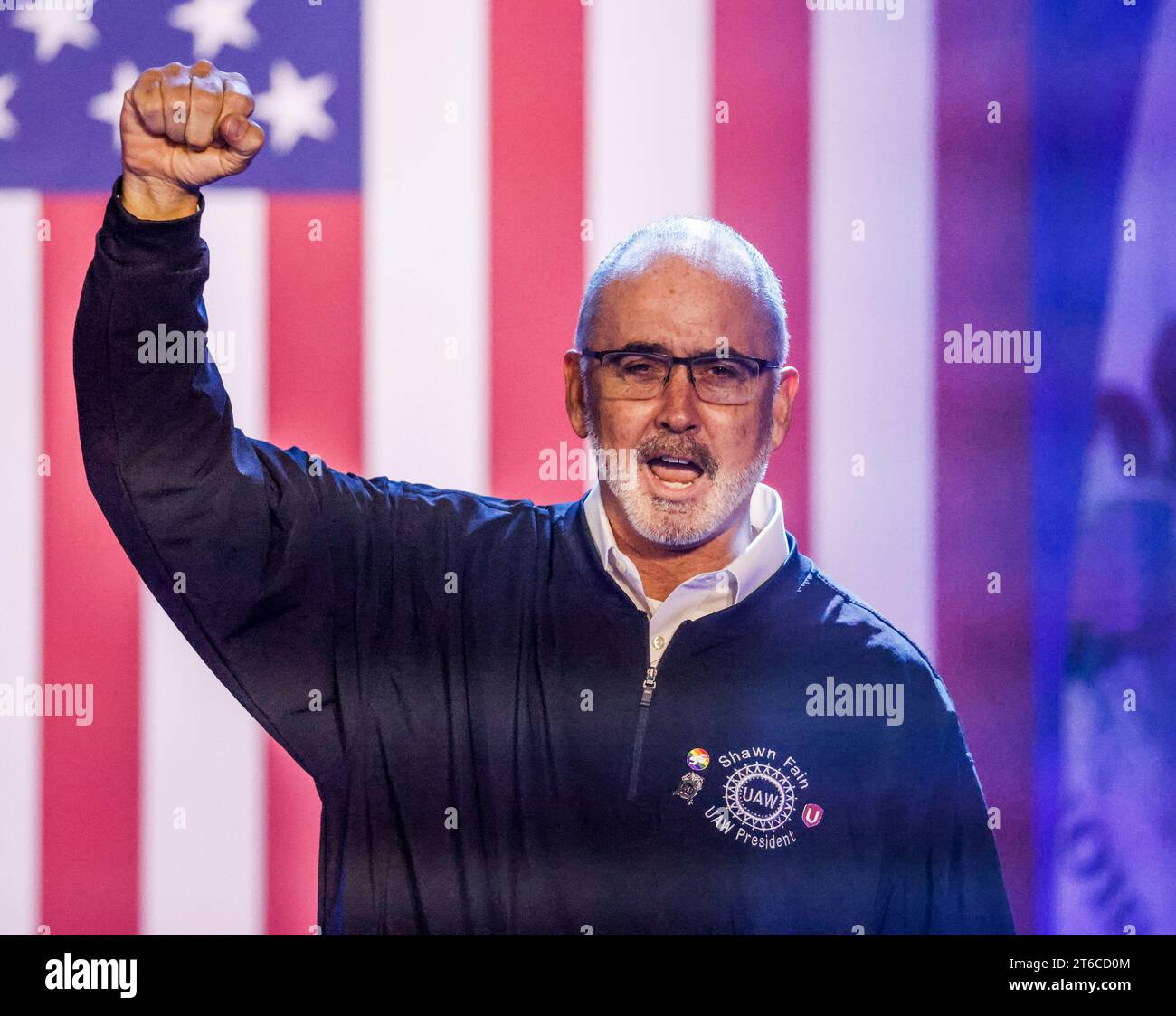 United Auto Workers President Shawn Fain raises his fist as he takes