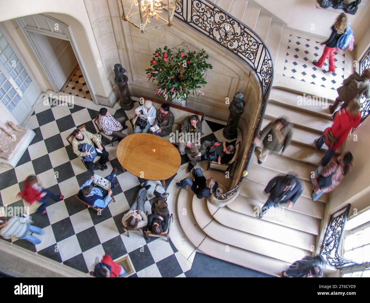 People taking a break in the foyer of The Rodin Museum which is housed in Rodin's old sculpture studio in Paris, France. - Stock Image