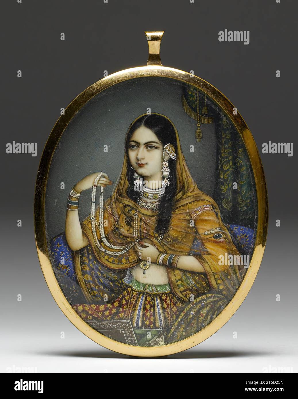 Portrait Miniature of an Indian Courtesan, 1830-1850. English artists visited India to paint both large-scale and miniature portraits of those serving abroad as mementos for friends and families back in the Mother Country. They introduced the European technique of painting in watercolours on ivory to the local artists. In this instance, an artist from Delhi has portrayed a courtesan dressed as a princess wearing elaborate Mughal gold and gem-set jewelry. Stock Photo