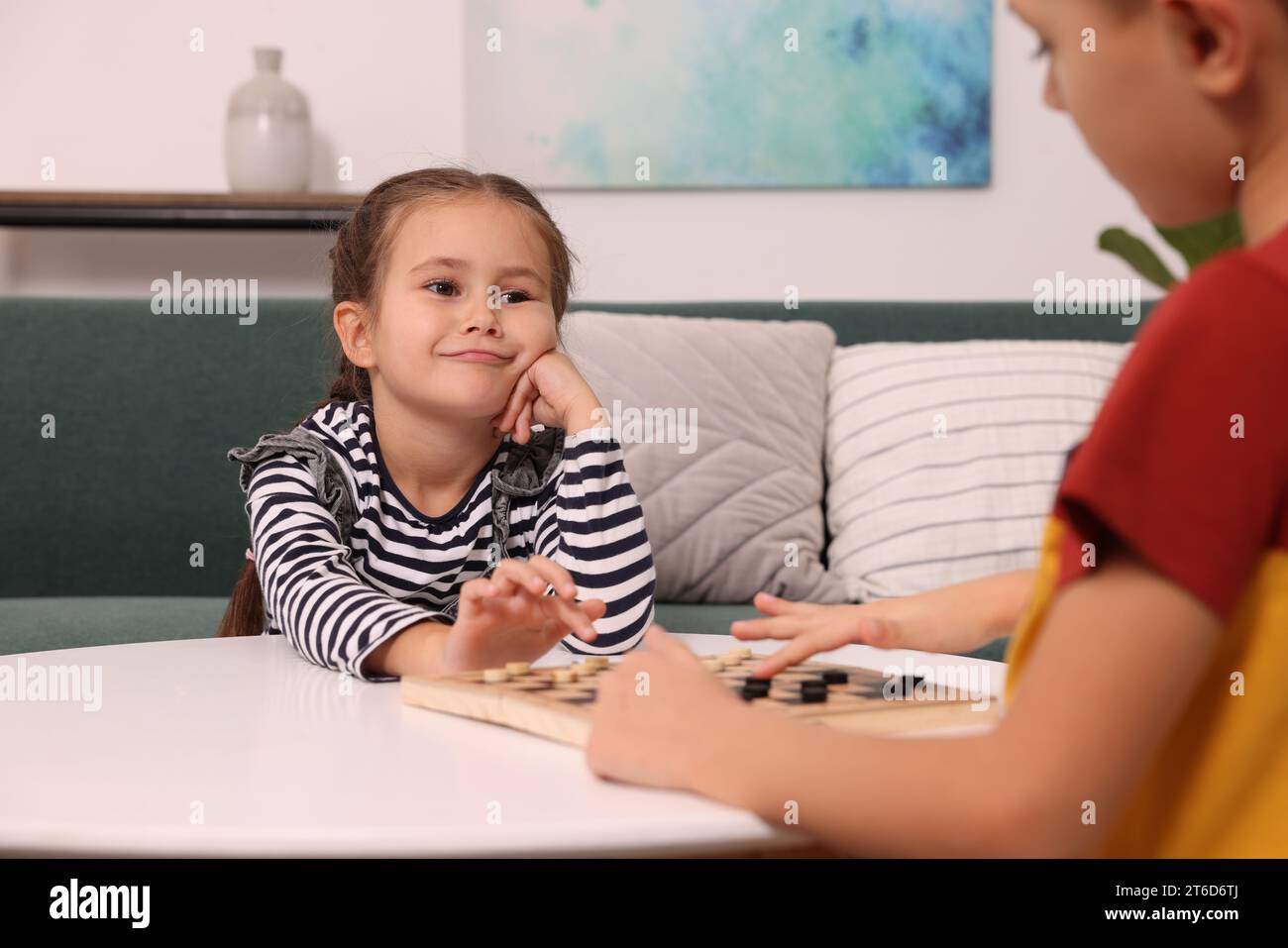 Children playing checkers at coffee table in room Stock Photo - Alamy