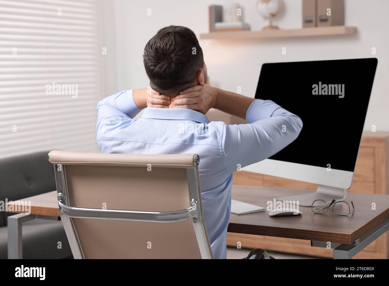 Man massaging stiff neck in office, back view Stock Photo - Alamy