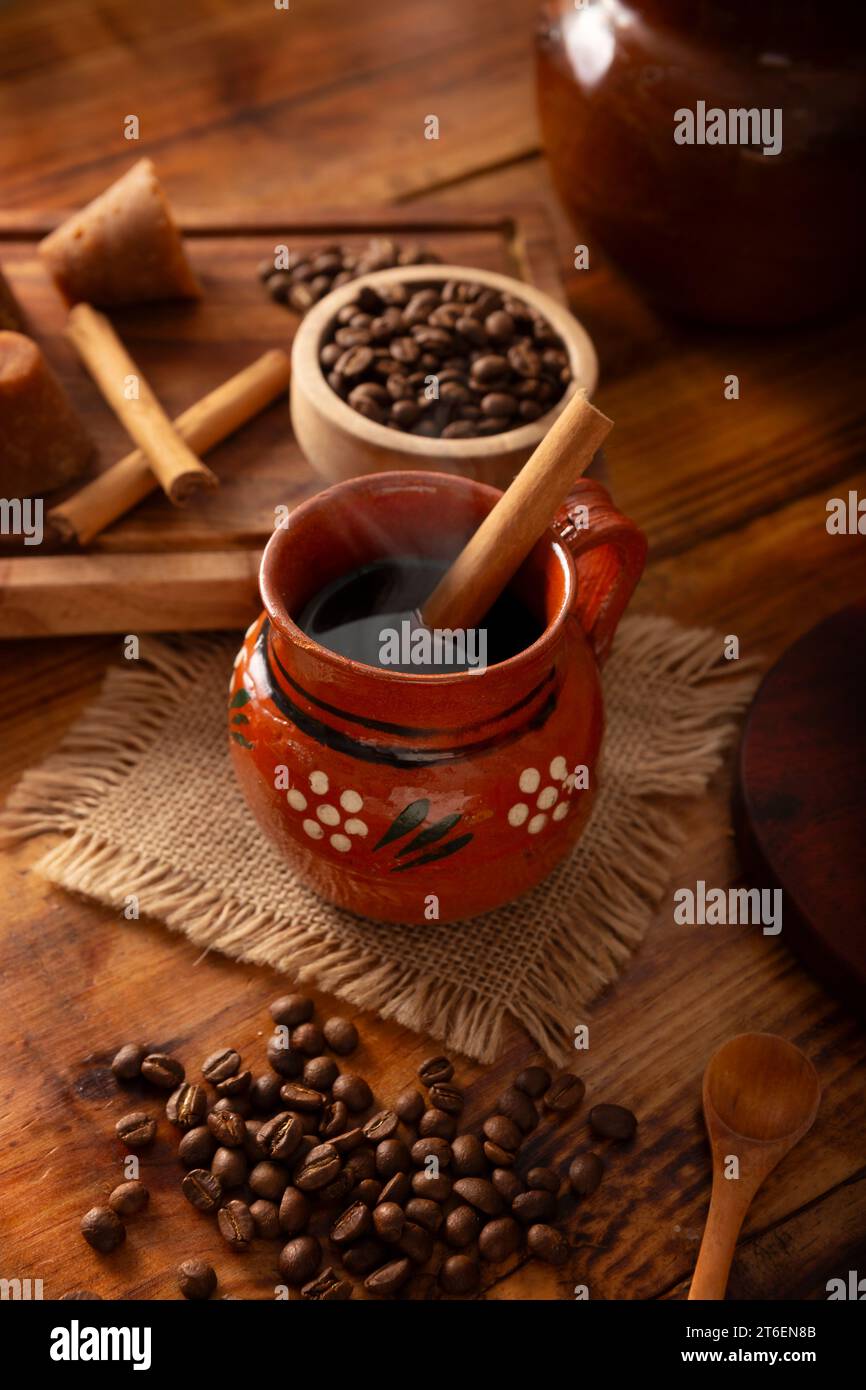 Cafe de Olla, Mexican-style coffee prepared with roasted and ground coffee beans, cinnamon and piloncillo. Traditional recipe prepared in a clay pot a Stock Photo